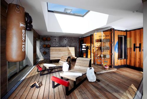 a room with chairs and tables on a wooden floor at 25hours Hotel Altes Hafenamt in Hamburg