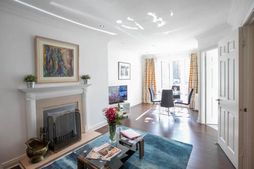 a living room with a fireplace and a table at Grand Canal District Apartments in Dublin