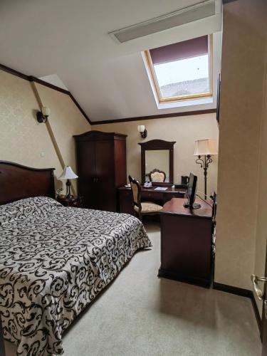 ein Schlafzimmer mit Bett, Schreibtisch und Fenster in der Unterkunft Hotel Carol in Constanţa