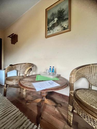 a wooden table with two chairs and a table with drinks on it at Zajazd Cicha Woda in Maniowy