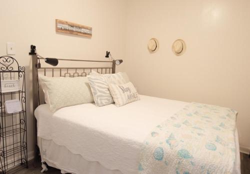 Una cama con sábanas blancas y almohadas en un dormitorio en 510 A The Beach Break Bungalow, en Virginia Beach