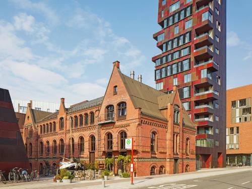 duży budynek z cegły obok wysokiego budynku w obiekcie 25hours Hotel Altes Hafenamt w mieście Hamburg