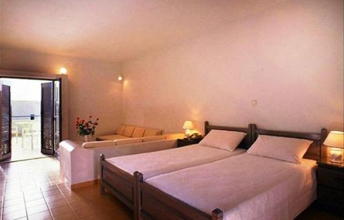sypialnia z 2 łóżkami i kanapą w obiekcie Blue Sky Hotel Apartments w mieście Tolo