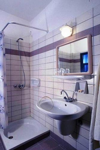 a bathroom with a sink and a mirror at Blue Sky Hotel Apartments in Tolo