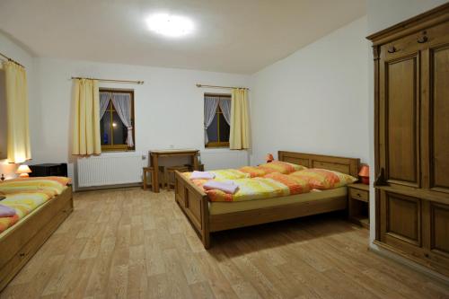 a bedroom with two beds and two windows at Resort Abertham - penzion Ellen in Abertamy