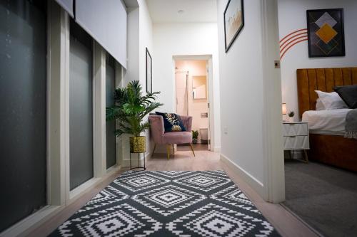 a hallway with a bedroom with a bed and a rug at Spacious Luxury Apartment in Stevenage, Sleeps 6, with Free Parking, and Free Wi-Fi in Stevenage