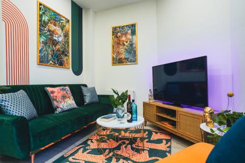 a living room with a green couch and a tv at Spacious Luxury Apartment in Stevenage, Sleeps 6, with Free Parking, and Free Wi-Fi in Stevenage