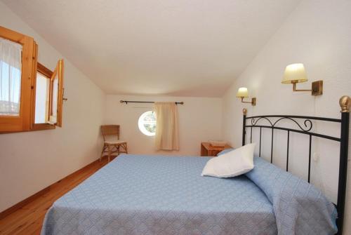 a bedroom with a blue bed and a window at Club Villamar - Andes in Lloret de Mar