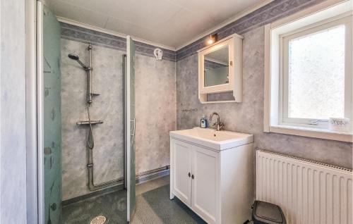 a bathroom with a shower and a sink and a mirror at Nice Home In Lngekrr With Kitchen in Klövedal
