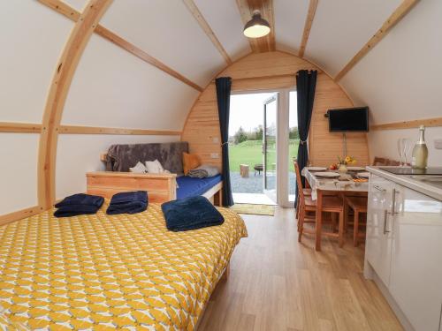 a bedroom with a bed in a room with a kitchen at Covey in Harpham