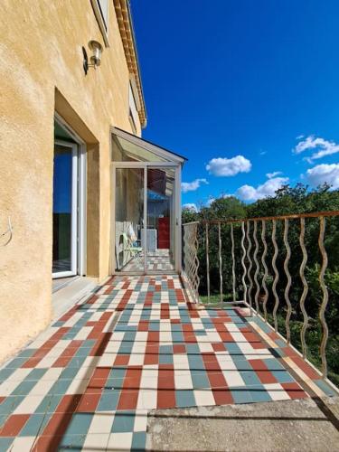 une maison avec un sol en damier sur un balcon dans l'établissement GITE Les Boyettes, à Le Teil