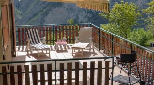 two chairs and a camera on a balcony with a view at La Source in Condamine-Châtelard