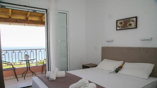 um quarto com uma cama e uma varanda em Panorama View em Agios Stefanos