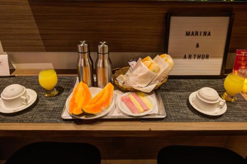 een dienblad met sinaasappelen en andere voedingsmiddelen op tafel bij Uno Prime Motel - Aricanduva in Sao Paulo