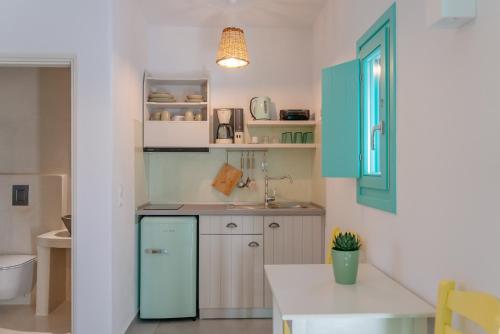 a kitchen with a blue refrigerator and a sink at Xerolithia Guesthouse in Donoussa