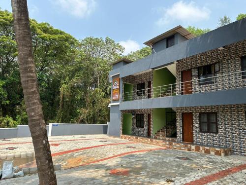 a building with a palm tree in front of it at ISHRA SERVICE APARTMENTS in Dharmastala