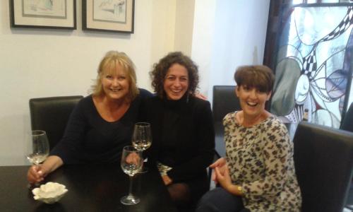 three women sitting around a table with wine glasses at Hotel La Casa in Torrox