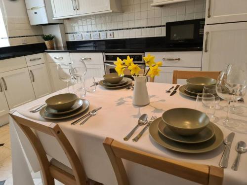 a kitchen with a table with plates and wine glasses at Large Modern Victorian Apartment in Ventnor