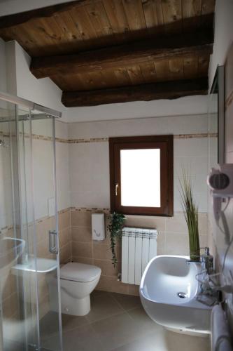 a bathroom with a toilet and a sink and a window at B&B Eden in LʼAquila