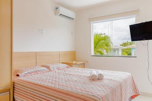 een slaapkamer met een bed met twee handdoeken erop bij GB07 Ótima Casa 4 Suítes com Piscina em Guarajuba in Guarajuba