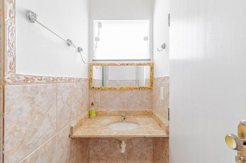 uma casa de banho com um lavatório e um espelho em GB07 Ótima Casa 4 Suítes com Piscina em Guarajuba em Guarajuba