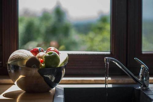 un bol de fruta sentado en un mostrador junto a una ventana en Mon Coup de Coeur en Hotton