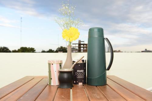 eine grüne Thermoskanne auf einem Tisch mit einer Vase in der Unterkunft DEPARTAMENTO CENTRICO in Dolores