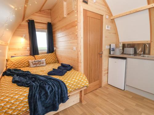 1 dormitorio con 1 cama en una casa pequeña en Bevy en Harpham