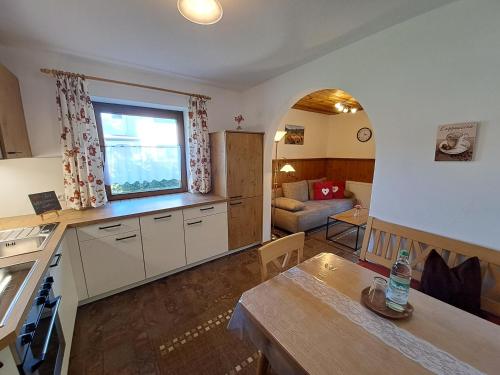 a kitchen and living room with a table and a window at Landerhauser-Hof in Schleching