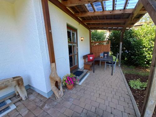 a patio with a table and a wooden roof at Landerhauser-Hof in Schleching