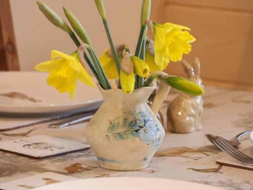 a vase filled with yellow flowers on a table at Husk in Harpham