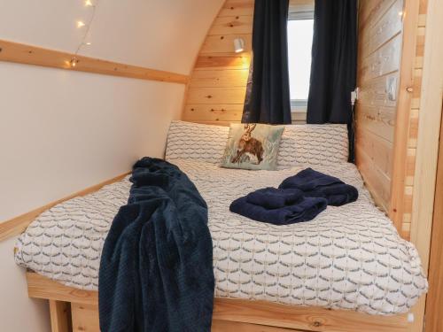 a bedroom with a bed with blue blankets on it at Husk in Harpham