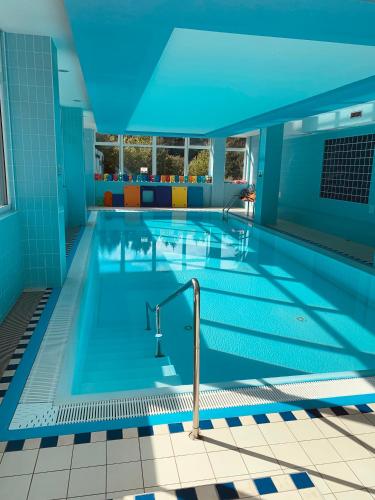 a large swimming pool with a blue ceiling at Horský hotel Jelenovská s bazénem v ceně in Valašské Klobouky