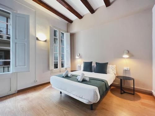 a bedroom with a large white bed and a table at Stay U-nique Apartments Vila de Gracia in Barcelona