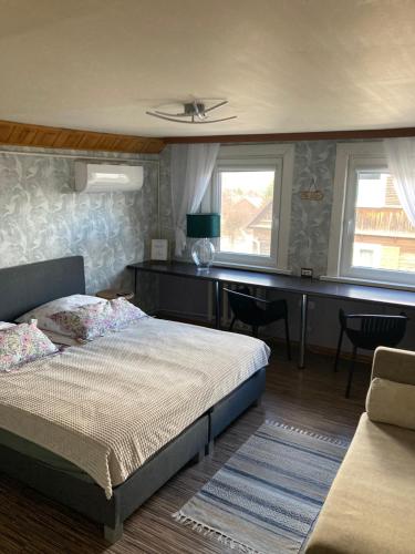 a bedroom with a bed and a desk at Pokoje Gościnne Nowy Świat in Supraśl