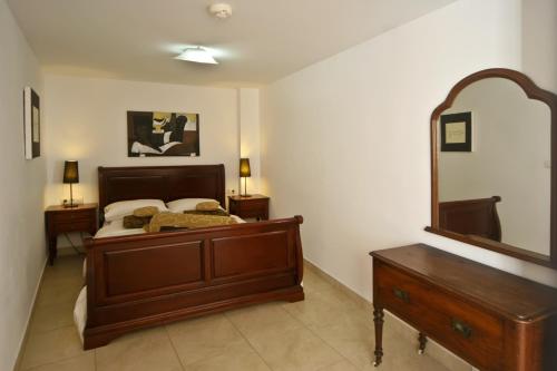 a bedroom with a bed and a dresser and a mirror at Hotel La Casa in Torrox