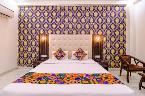 a bedroom with a large bed and a chair at FabHotel Swess Grand in Agra
