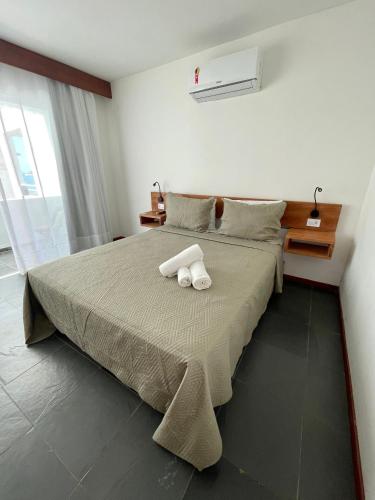 a bedroom with a bed with two towels on it at Orlanova Hotel in Arraial do Cabo
