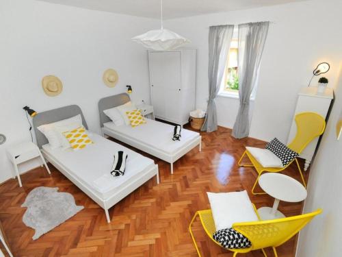 a living room with two couches and yellow chairs at Downtown apartment Tango in Zadar