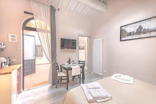 a bedroom with a bed and a table and a kitchen at Montechiari In Chianti in Greve in Chianti