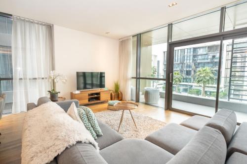 sala de estar con sofá y TV en FAM Living - City Walk - Urban Staycations, en Dubái