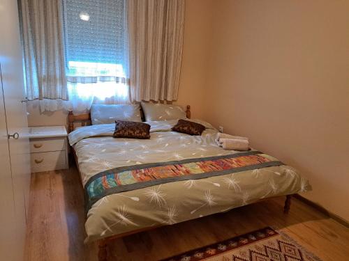 ein kleines Bett in einem Schlafzimmer mit Fenster in der Unterkunft Arda Riverside Apartment in Kardschali