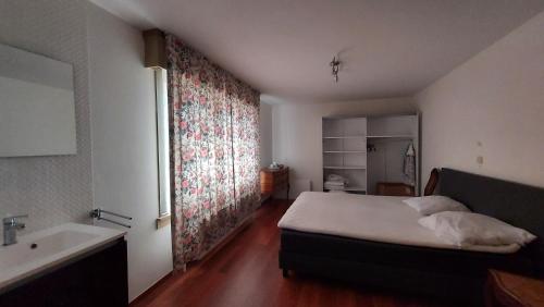 a bedroom with a bed and a bathroom with a sink at Villa Duinberg R-002 in Koksijde