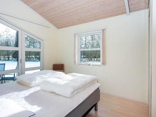 a white bedroom with a bed and windows at Holiday home Vemb VI in Vemb