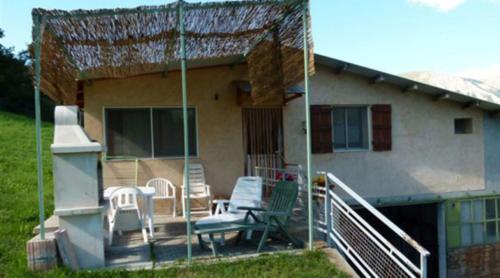 Cette maison dispose d'une terrasse couverte avec des chaises et une table. dans l'établissement La Bergerie, à Condamine-Châtelard