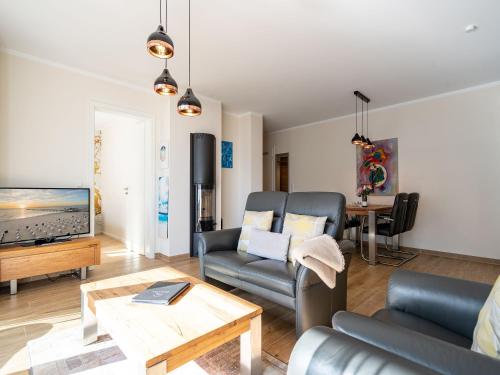 ein Wohnzimmer mit einem Sofa und einem TV in der Unterkunft Quartier Frohsinn, App. 08 in Ahlbeck