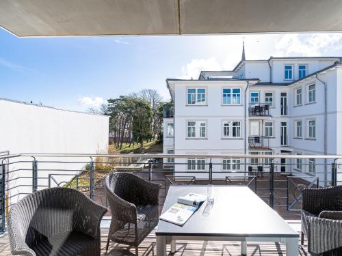 einen Balkon mit einem Tisch und Stühlen sowie ein Gebäude in der Unterkunft Quartier Frohsinn, App. 08 in Ahlbeck