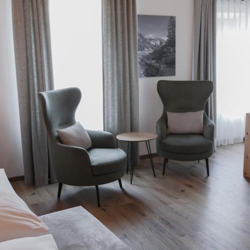 two chairs and a table in a hotel room at Hotel Baer & Post Zernez in Zernez
