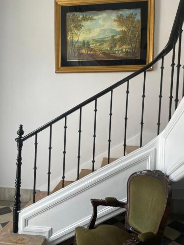 a stairway with a painting on the wall and a chair at Thomar House in Tomar