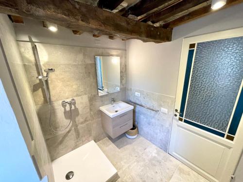 a bathroom with a shower and a toilet and a sink at Palazzo Minzoni in SantʼIppolito